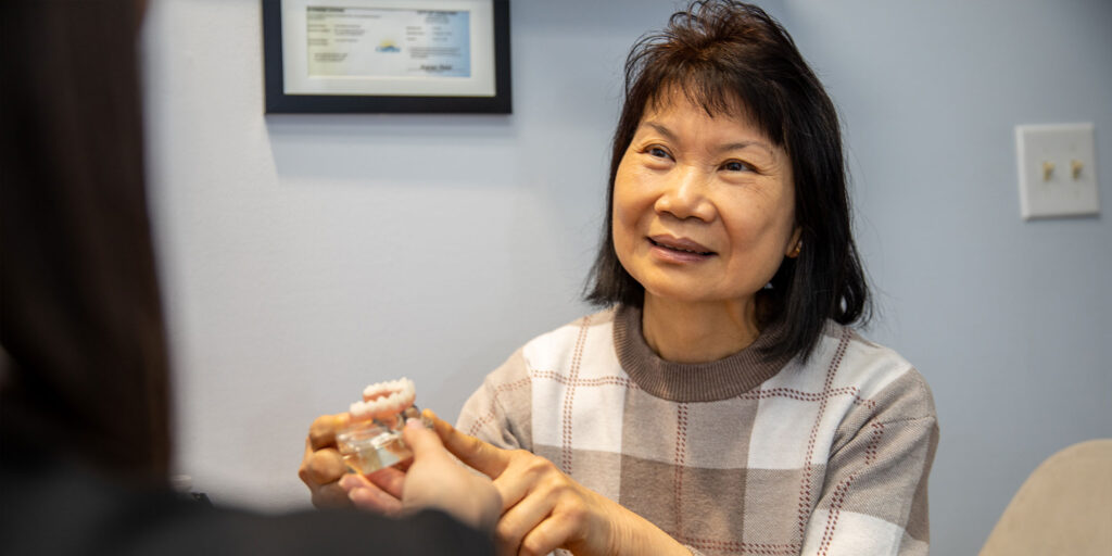 Patient and staff member discussing information of dental implant procedure