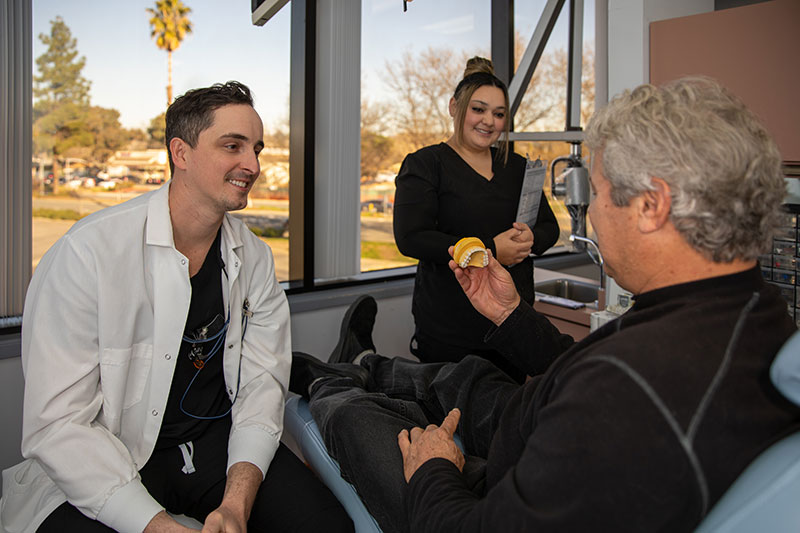 Dr. Ewing showing implant model to dental implant patient